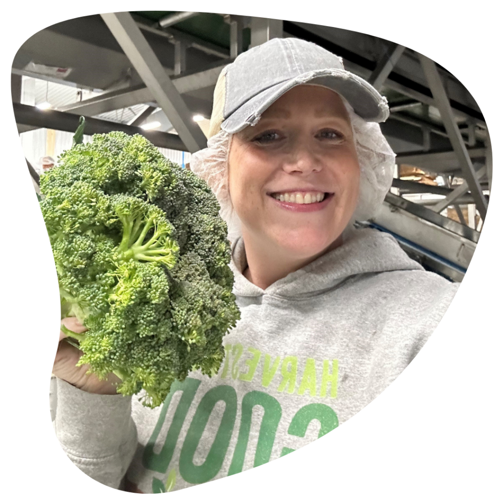 Profile picture for Melissa Motejunas. Holding a floret of broccoli in a Harvesting Good sweatshirt. 